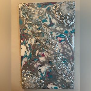 Wood fluid poured painting with added stones and a resin finish
